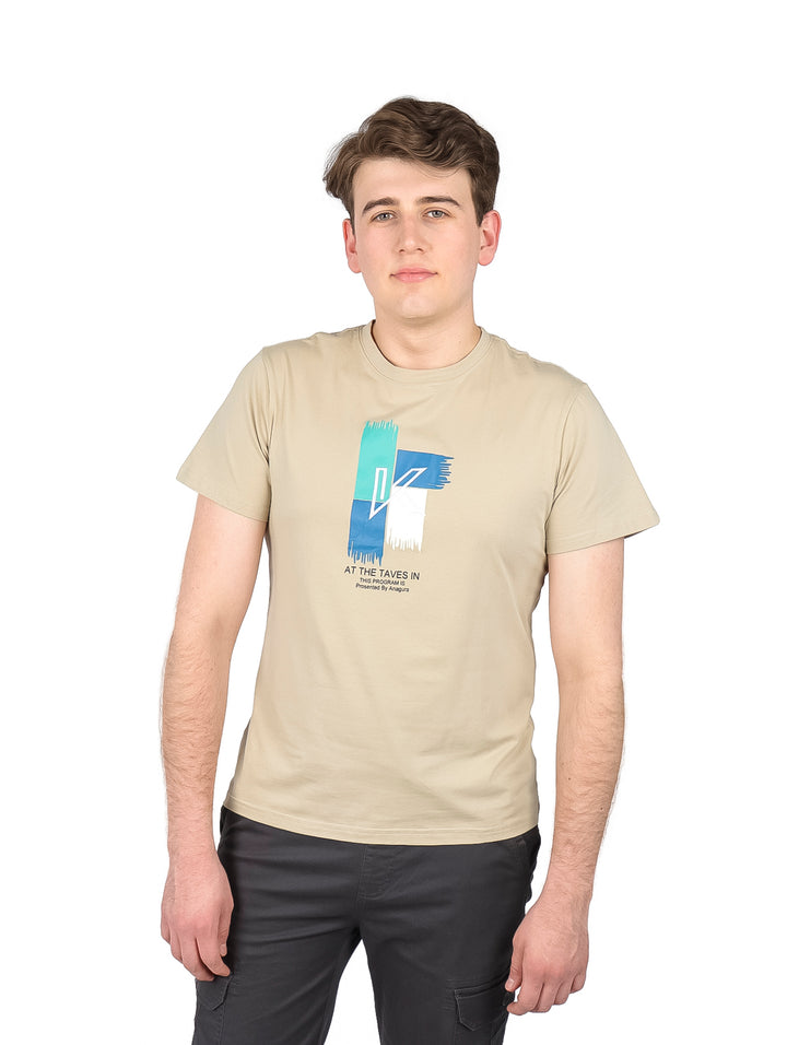 Hombre vistiendo playera color khaki de manga corta con estampado gráfico en el pecho y cuello redondo.