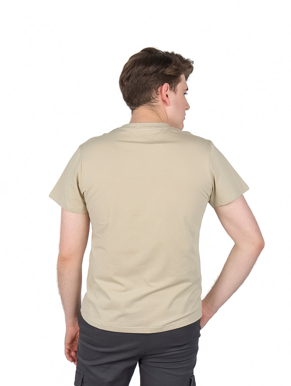 Hombre vistiendo playera color khaki de manga corta con estampado gráfico en el pecho y cuello redondo.