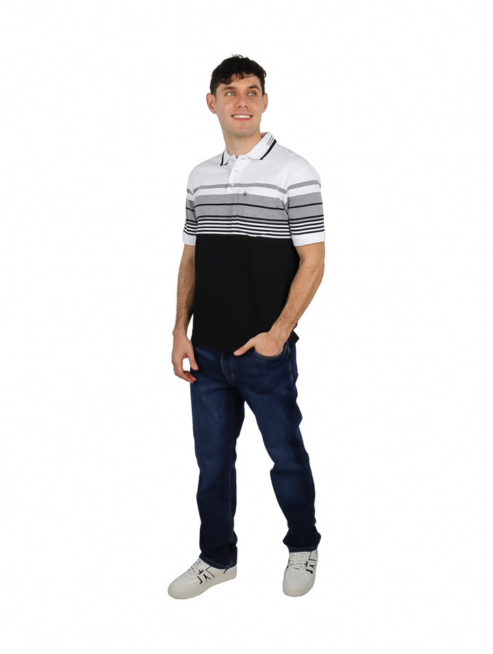 Hombre vistiendo playera polo de manga corta con diseño de bloques de color blanco, gris y negro.