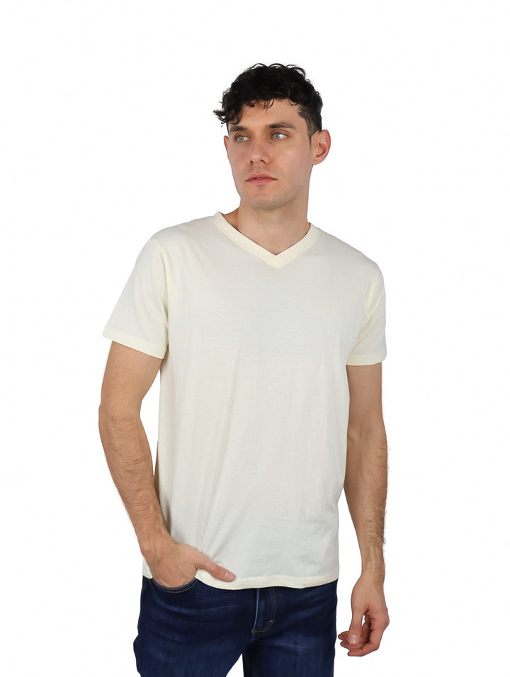 Hombre vistiendo una playera beige de cuello en V y manga corta.