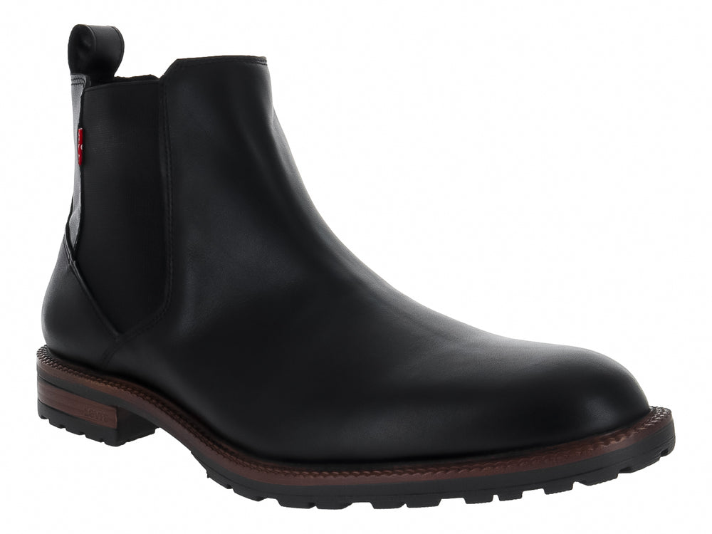 Bota estilo Chelsea color negro con suela marrón y panel elástico lateral.