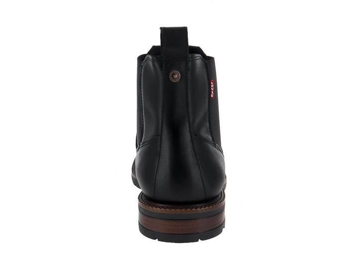 Bota estilo Chelsea color negro con suela marrón y panel elástico lateral.