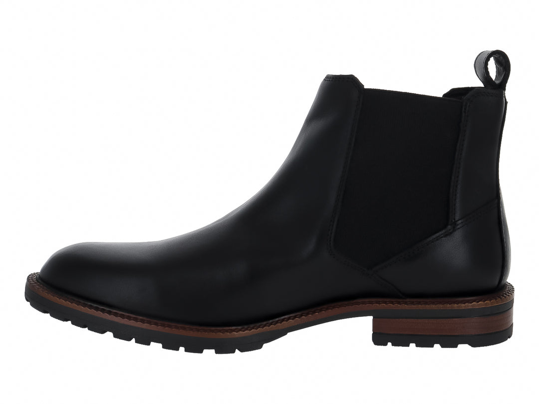 Bota estilo Chelsea color negro con suela marrón y panel elástico lateral.