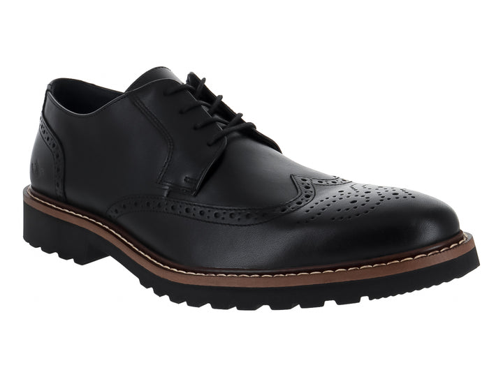 Zapato Oxford negro de cuero con detalles perforados tipo brogue y suela gruesa color café y negro.