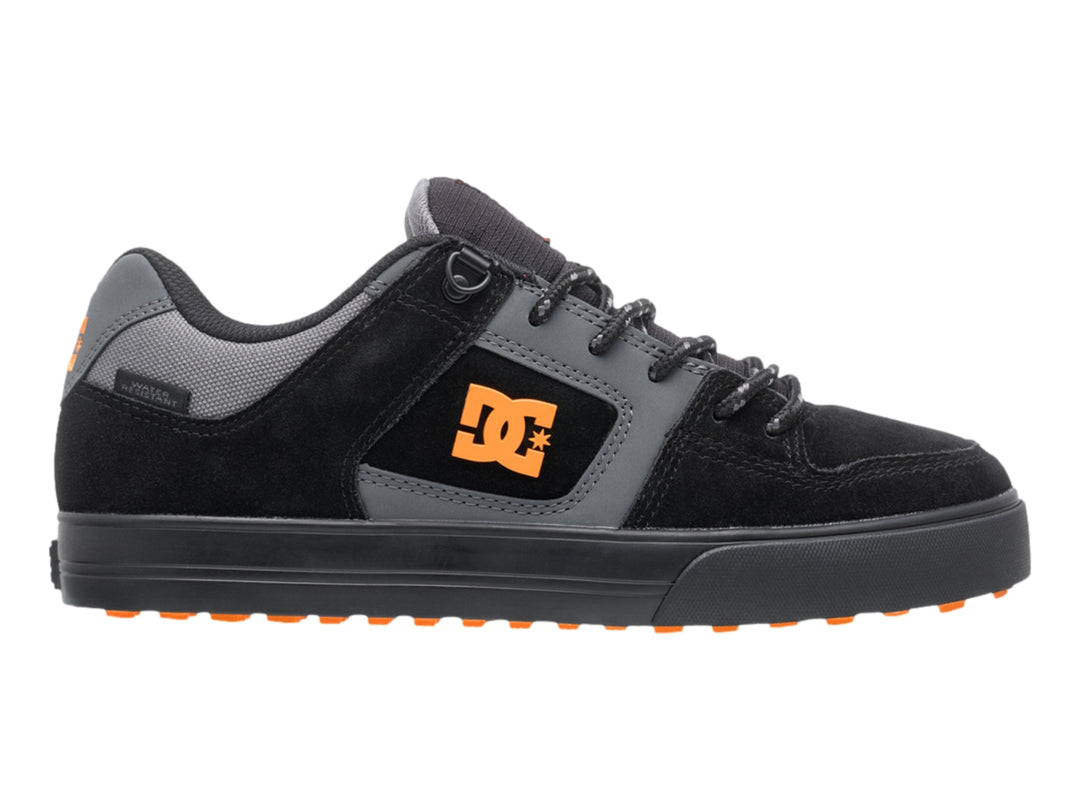 Tenis DC Shoes color negro y gris con logotipo naranja y suela negra, vista lateral.