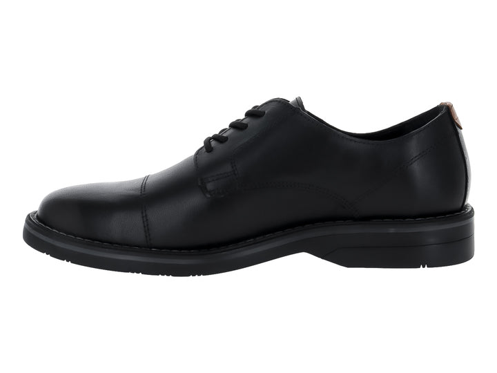 Zapato formal negro de cuero con cordones y suela negra.