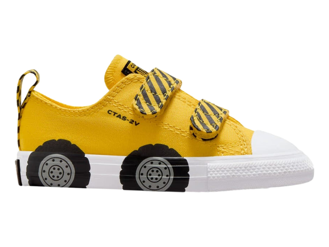 Tenis Converse infantiles amarillos con diseño de llantas negras en la suela blanca y cierres de velcro.
