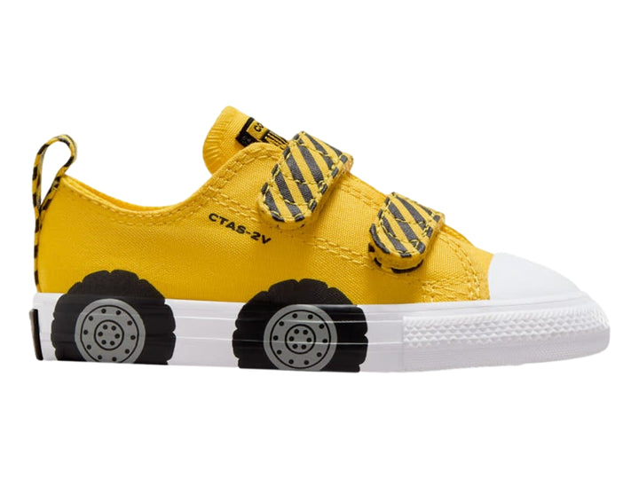 Tenis Converse infantiles amarillos con diseño de llantas negras en la suela blanca y cierres de velcro.
