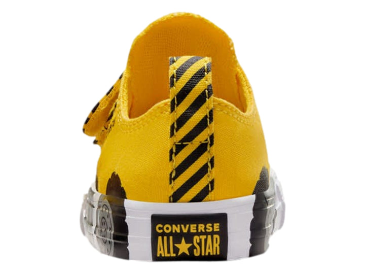 Tenis Converse infantiles amarillos con diseño de llantas negras en la suela blanca y cierres de velcro.