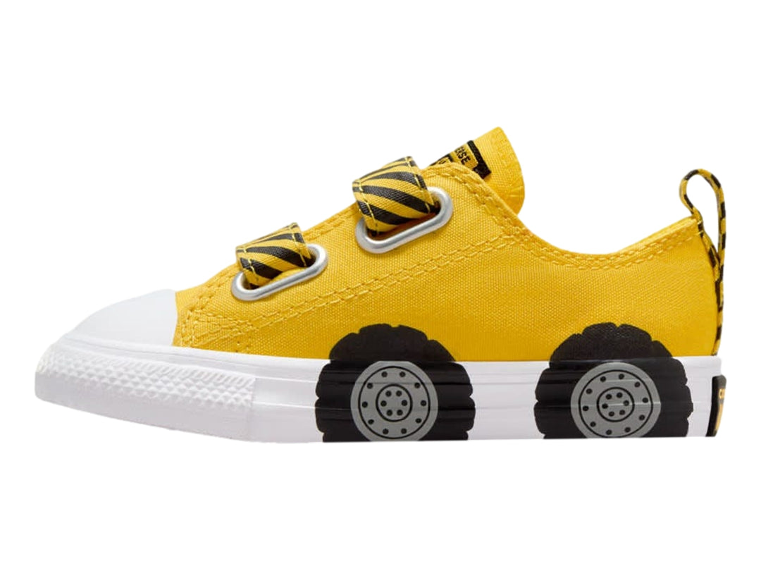 Tenis Converse infantiles amarillos con diseño de llantas negras en la suela blanca y cierres de velcro.
