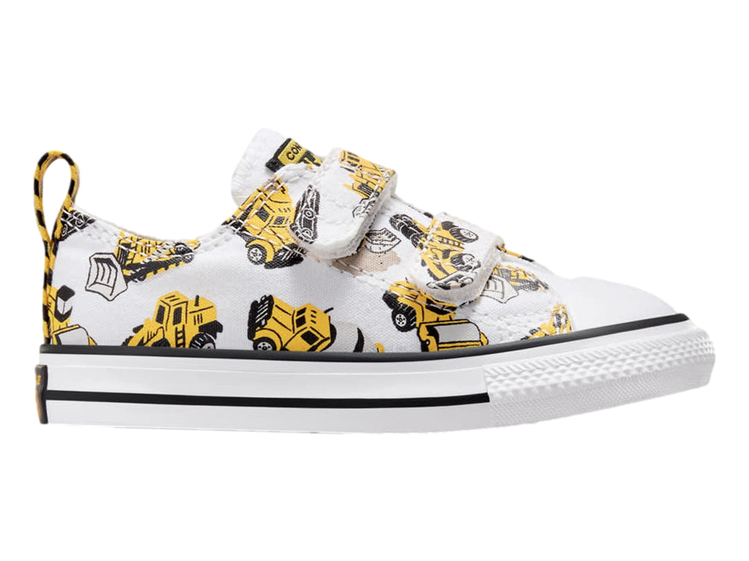 Tenis Converse blancos con estampado de camiones de construcción amarillos y cierres de velcro.