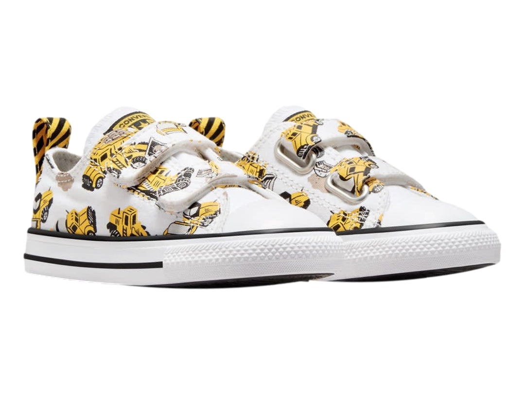 Tenis Converse blancos con estampado de camiones de construcción amarillos y cierres de velcro.