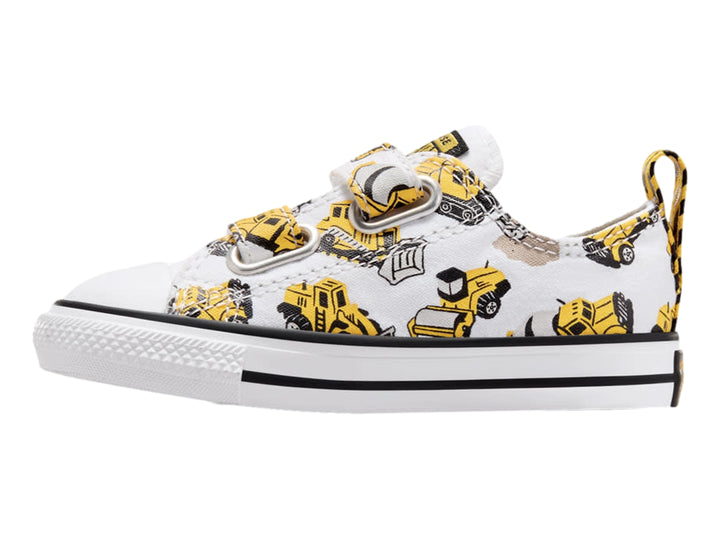 Tenis Converse blancos con estampado de camiones de construcción amarillos y cierres de velcro.