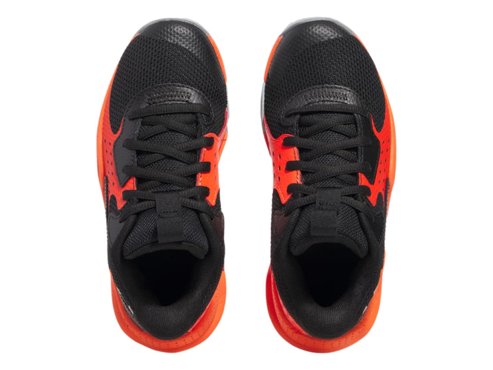 Tenis de baloncesto Under Armour color negro con detalles en naranja y suela gris.