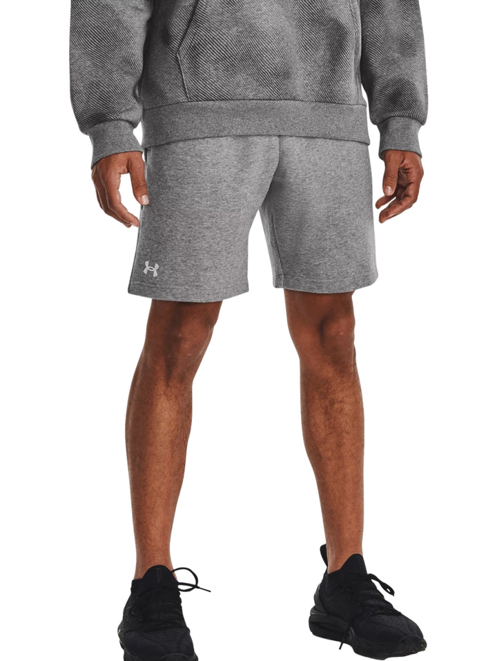 Hombre vistiendo shorts deportivos de color gris marca Under Armour.