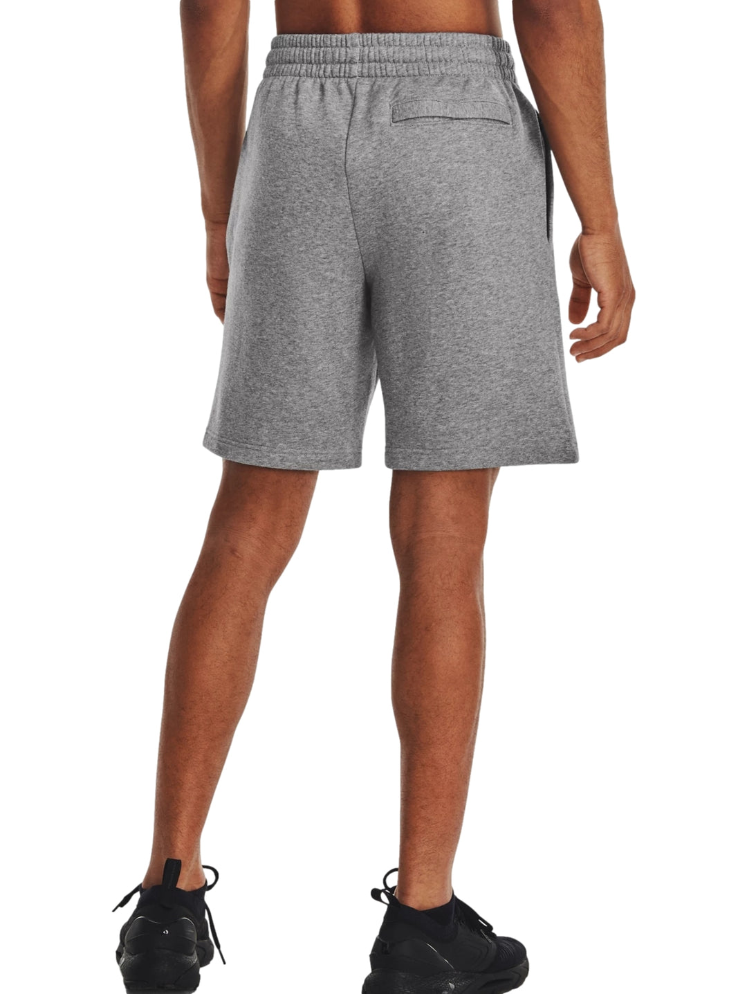 Hombre vistiendo shorts deportivos de color gris marca Under Armour.