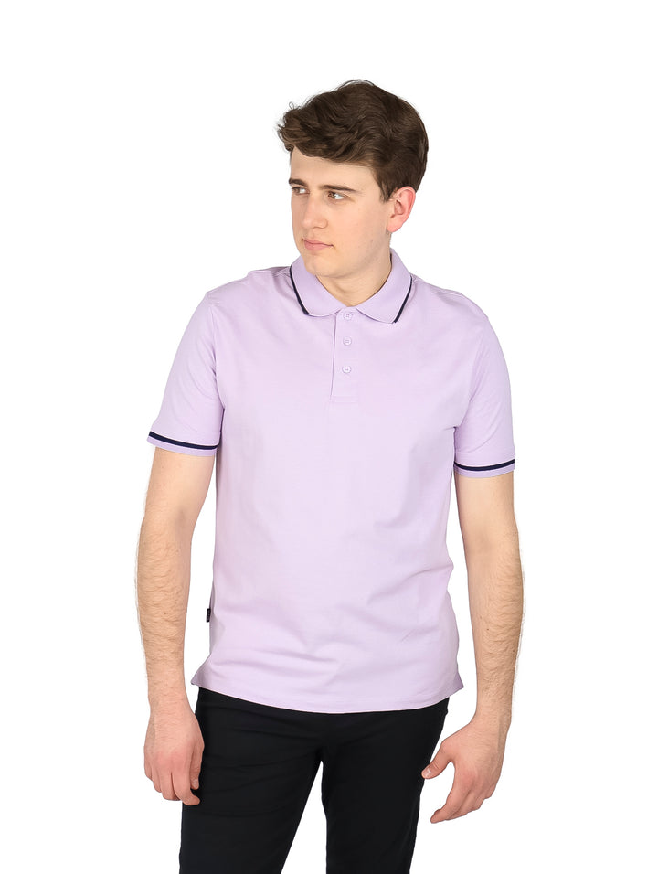 Hombre usando playera polo color lavanda con ribete oscuro en cuello y mangas.