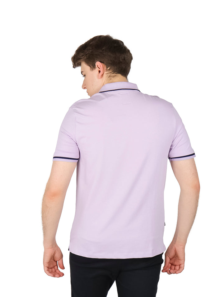 Hombre usando playera polo color lavanda con ribete oscuro en cuello y mangas.