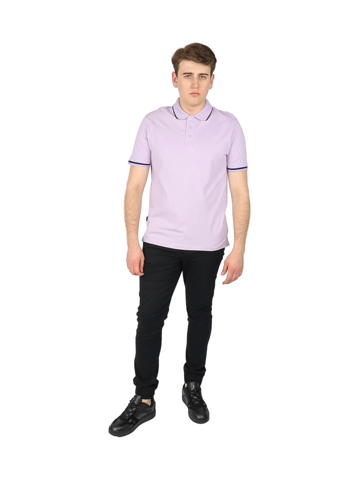 Hombre usando playera polo color lavanda con ribete oscuro en cuello y mangas.