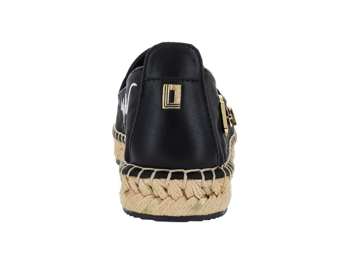 Zapato plano tipo alpargata negro con suela de yute y pines metálicos dorados.