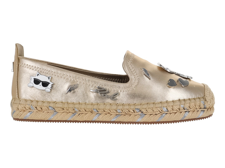 Zapato plano tipo alpargata color dorado metálico con detalles decorativos y suela trenzada.