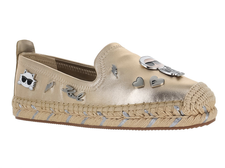 Zapato plano tipo alpargata color dorado metálico con detalles decorativos y suela trenzada.
