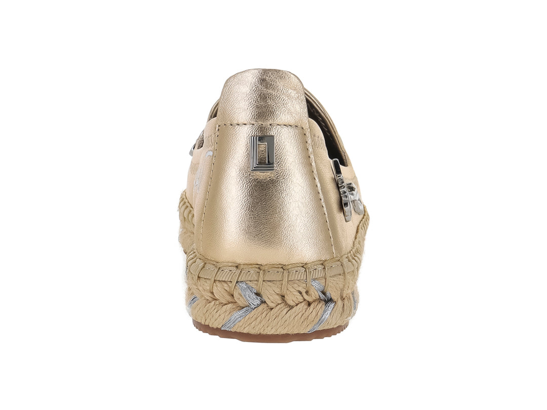 Zapato plano tipo alpargata color dorado metálico con detalles decorativos y suela trenzada.