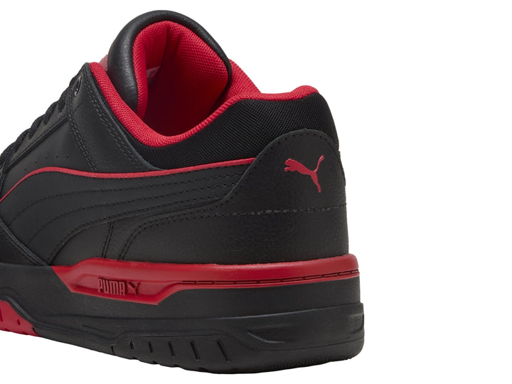 Tenis PUMA Rebound Retro en color negro con detalles en rojo y suela negra.