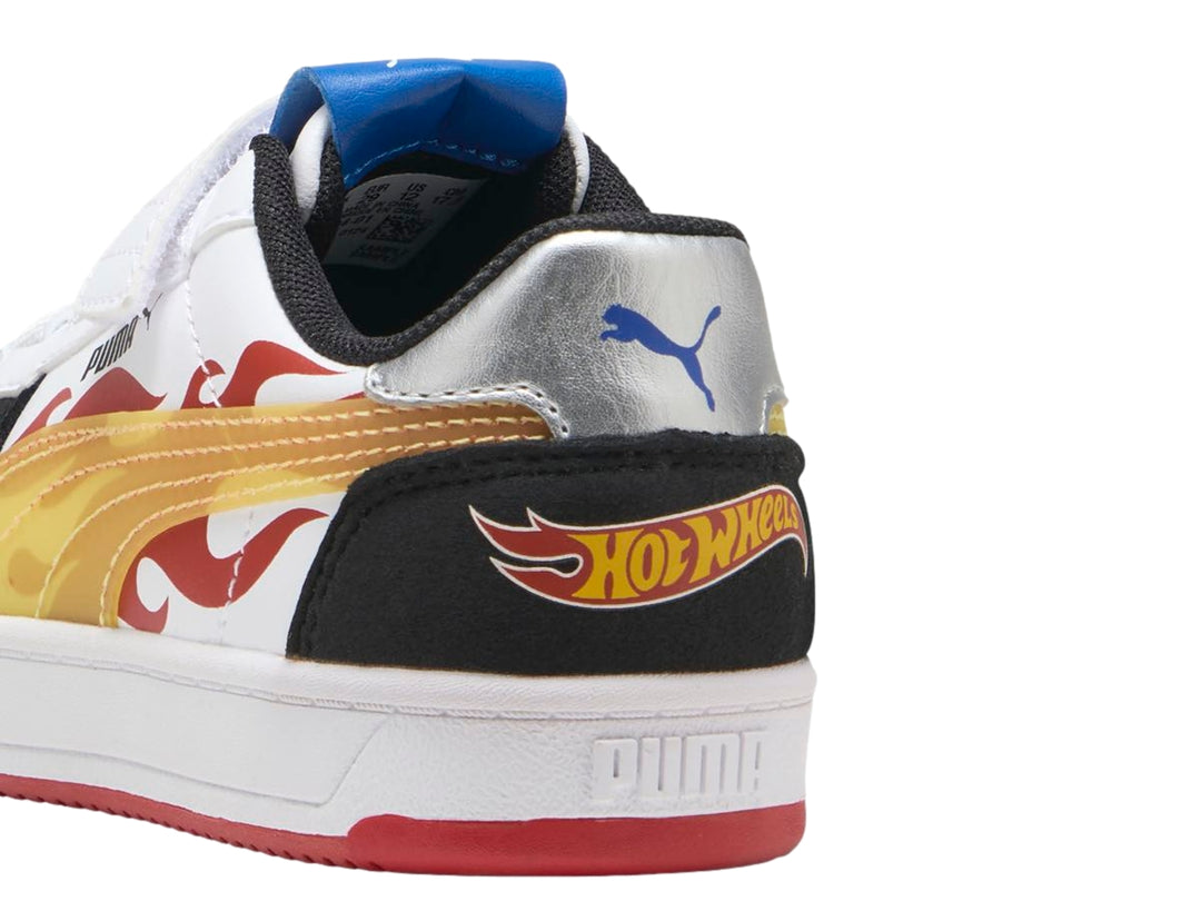 Tenis PUMA blancos con detalles en negro, amarillo y suela roja, diseño Hot Wheels para niños.