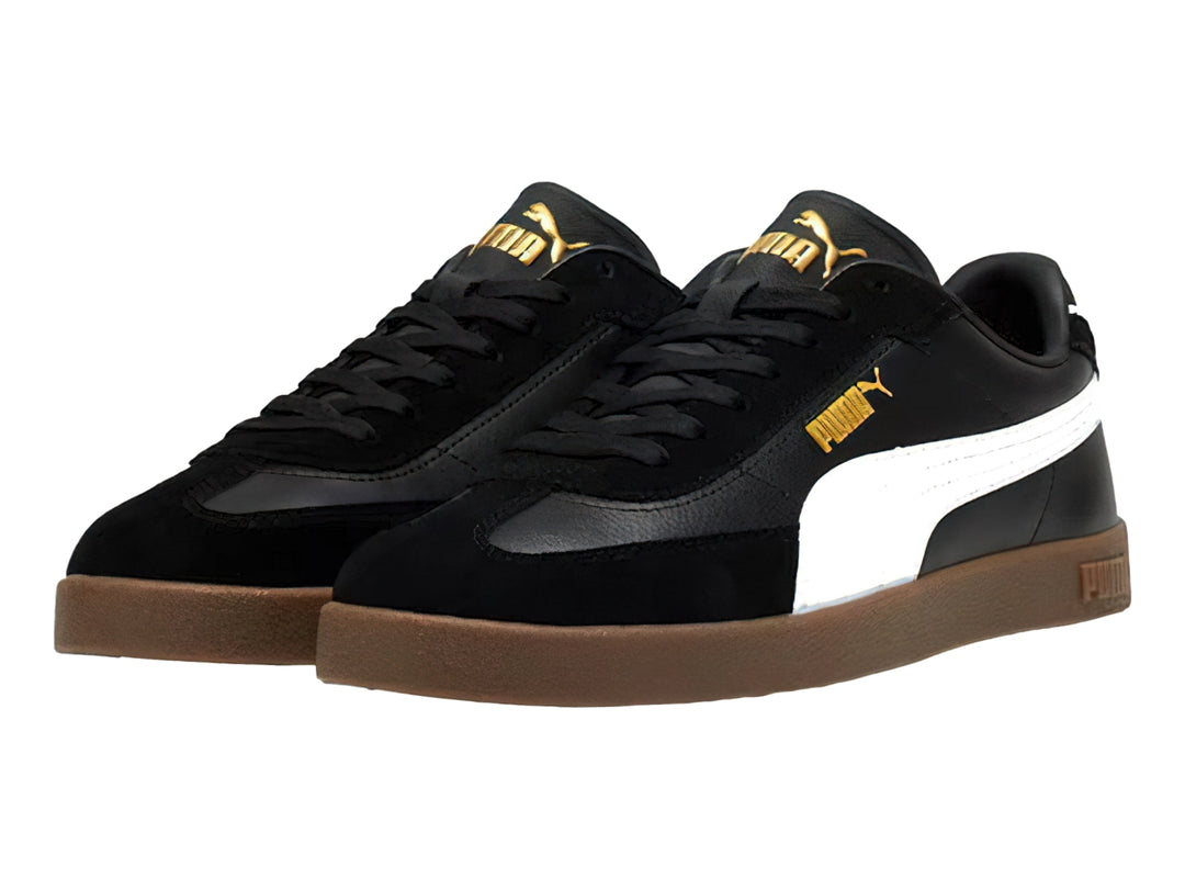 Tenis PUMA negros con franja blanca lateral y suela de goma color café.