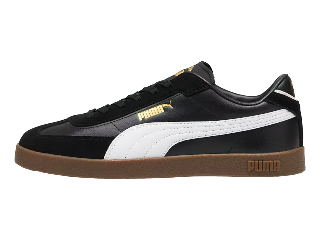 Tenis PUMA negros con franja blanca lateral y suela de goma color café.