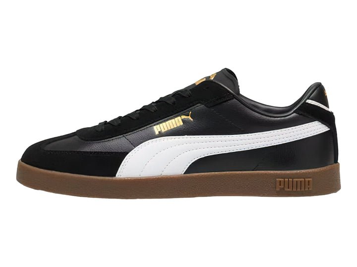Tenis PUMA negros con franja blanca lateral y suela de goma color café.