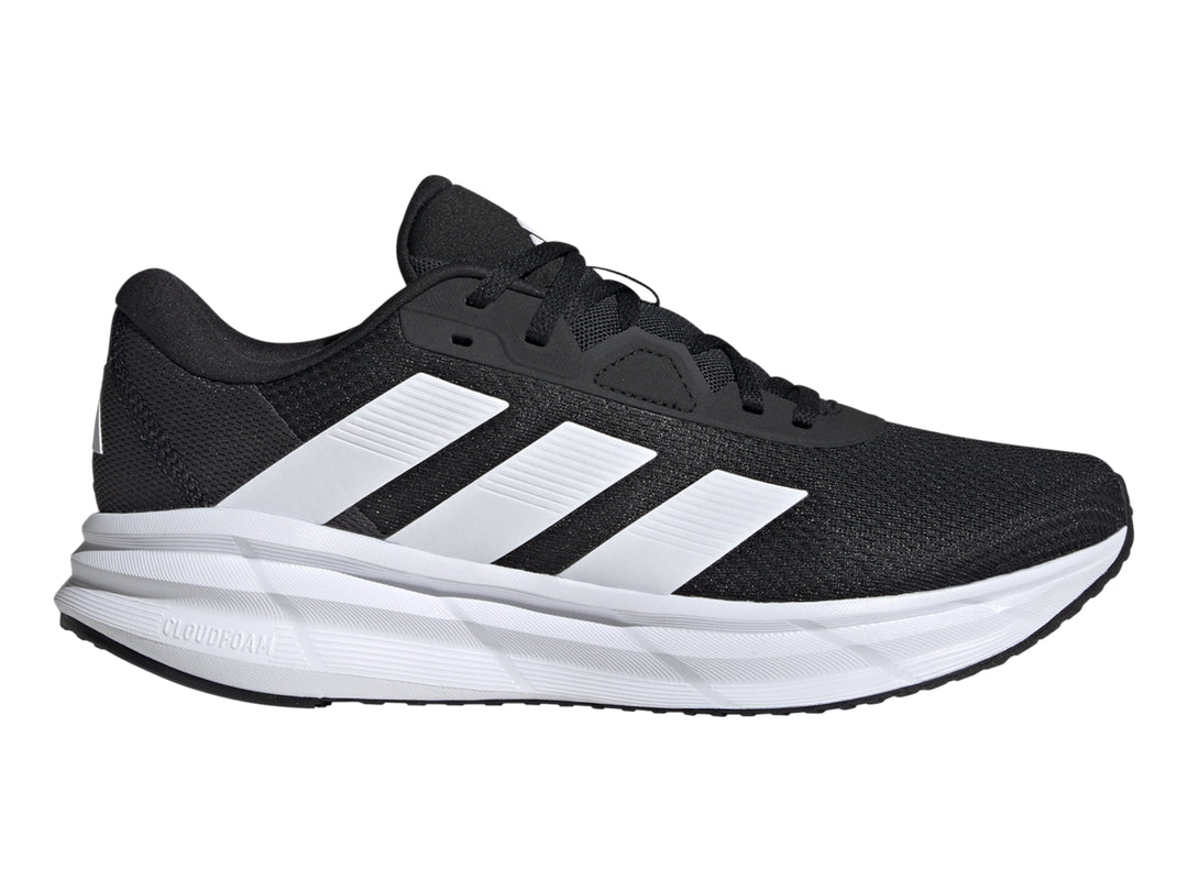 Tenis Adidas Galaxy 7 color negro con franjas y suela blanca, vista lateral.