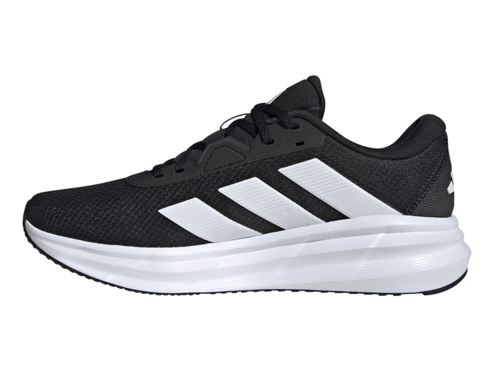 Tenis Adidas Galaxy 7 color negro con franjas y suela blanca, vista lateral.