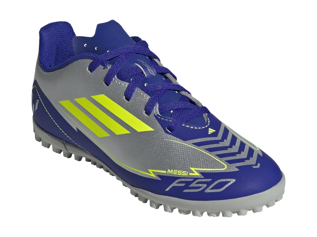 Zapato de fútbol Adidas F50 Club TF en color plata con detalles en azul y amarillo sobre fondo blanco.