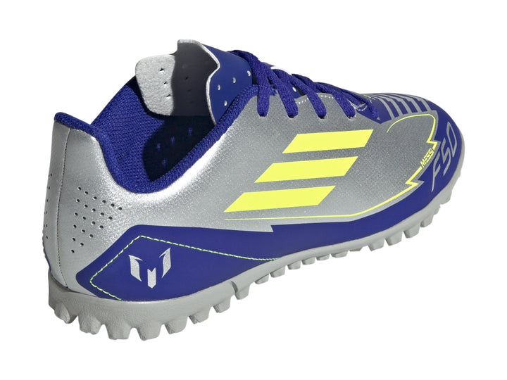 Zapato de fútbol Adidas F50 Club TF en color plata con detalles en azul y amarillo sobre fondo blanco.