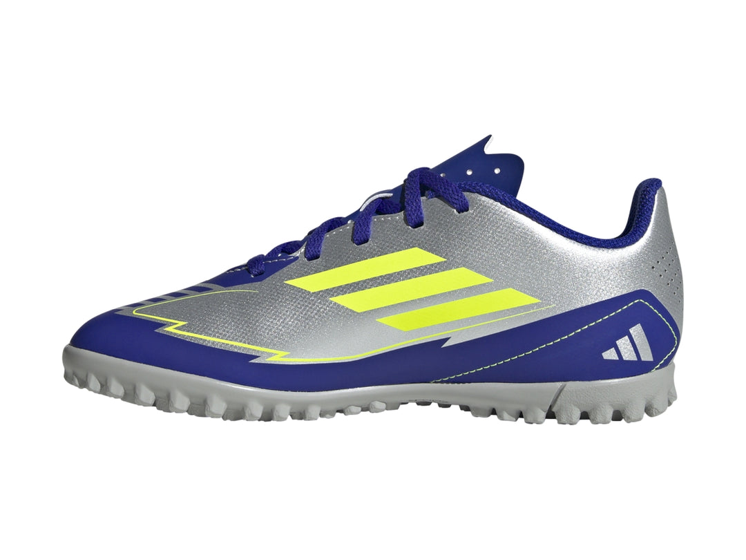 Zapato de fútbol Adidas F50 Club TF en color plata con detalles en azul y amarillo sobre fondo blanco.