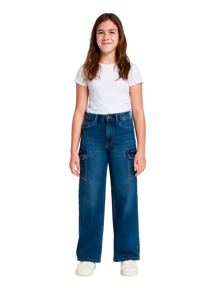 Niña vistiendo pantalón cargo de mezclilla azul de pierna ancha y camiseta blanca.
