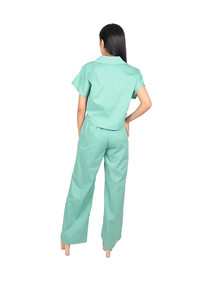 Conjunto de blusa y pantalón ancho en color verde sage con detalles de rayas blancas laterales.