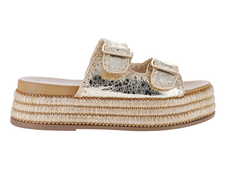 Sandalia dorada de plataforma con tiras metálicas y hebillas, suela tejida tipo espadrille.