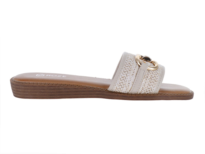 Sandalia plana color beige para mujer con banda tejida y hebilla metálica dorada.