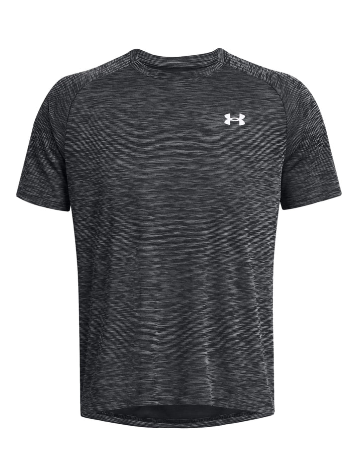 Hombre vistiendo playera deportiva Under Armour de color gris jaspeado con manga corta y cuello redondo.