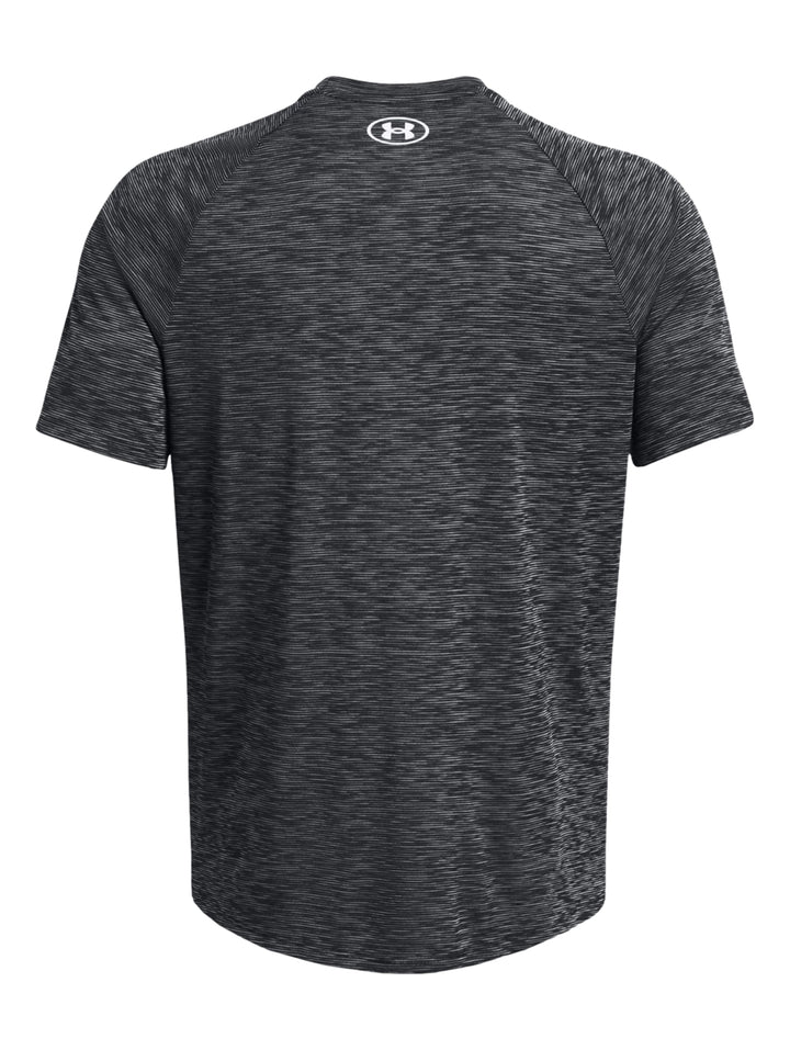 Hombre vistiendo playera deportiva Under Armour de color gris jaspeado con manga corta y cuello redondo.