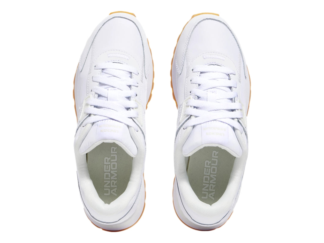 Tenis deportivos Under Armour color blanco con suela de goma color miel.