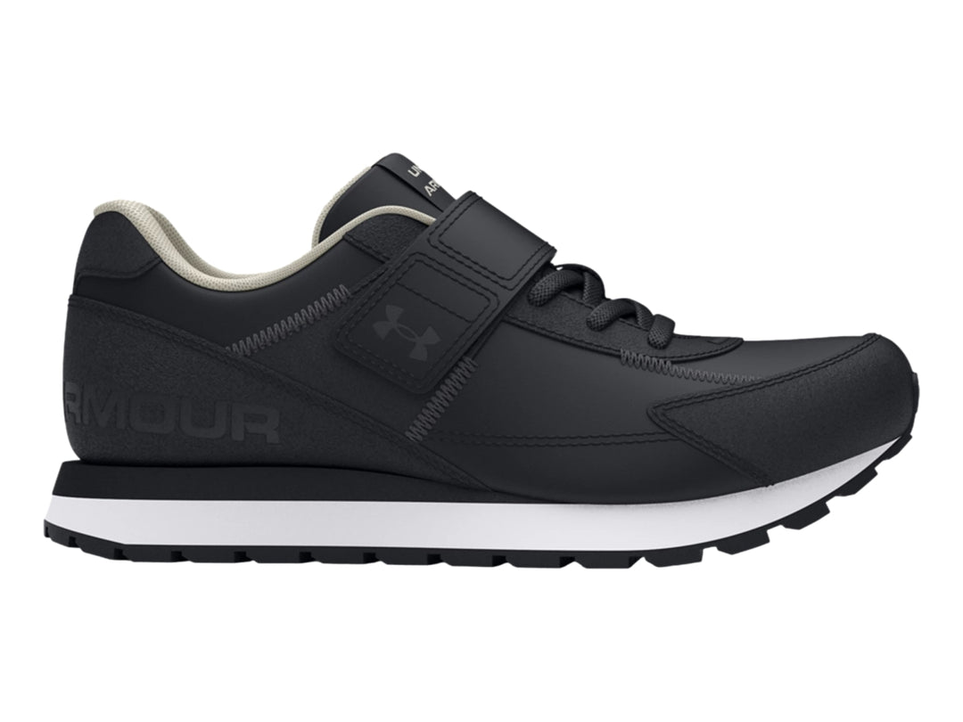 Tenis deportivos Under Armour color negro con suela blanca y cierre de cinta de velcro para niño.