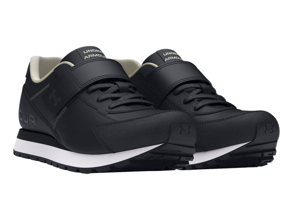Tenis deportivos Under Armour color negro con suela blanca y cierre de cinta de velcro para niño.