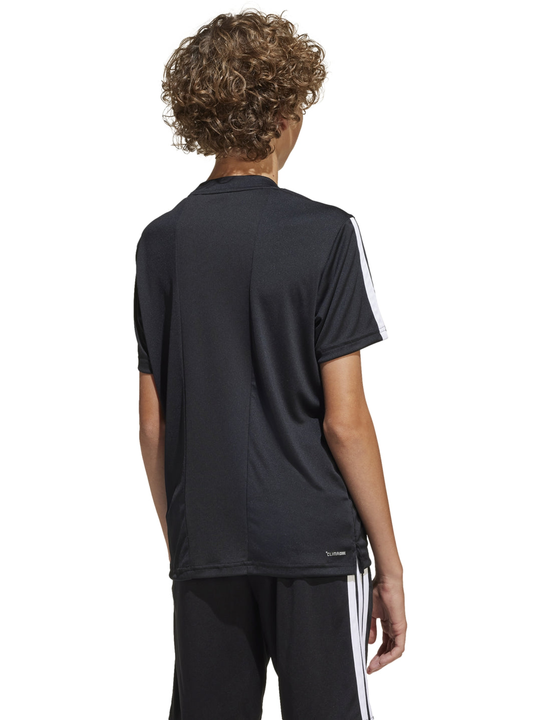 Niño vistiendo camiseta deportiva Adidas color negro con tres franjas blancas en los hombros.