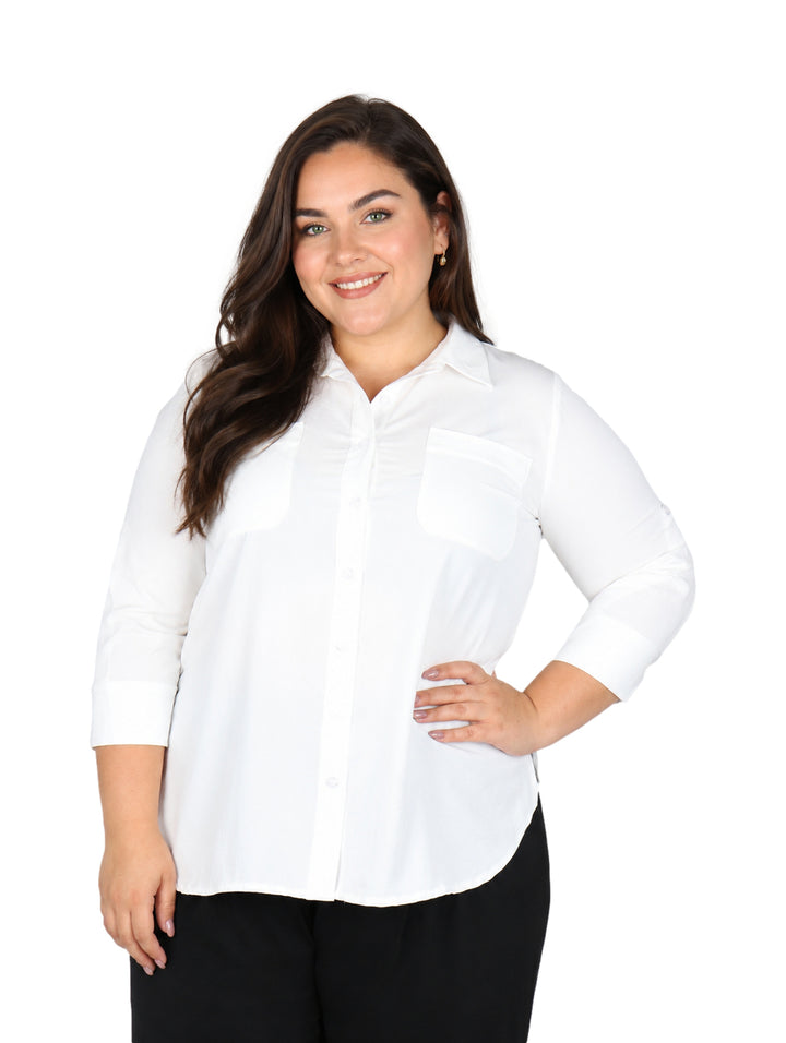 Mujer vistiendo una blusa blanca de manga tres cuartos con cuello y botones.