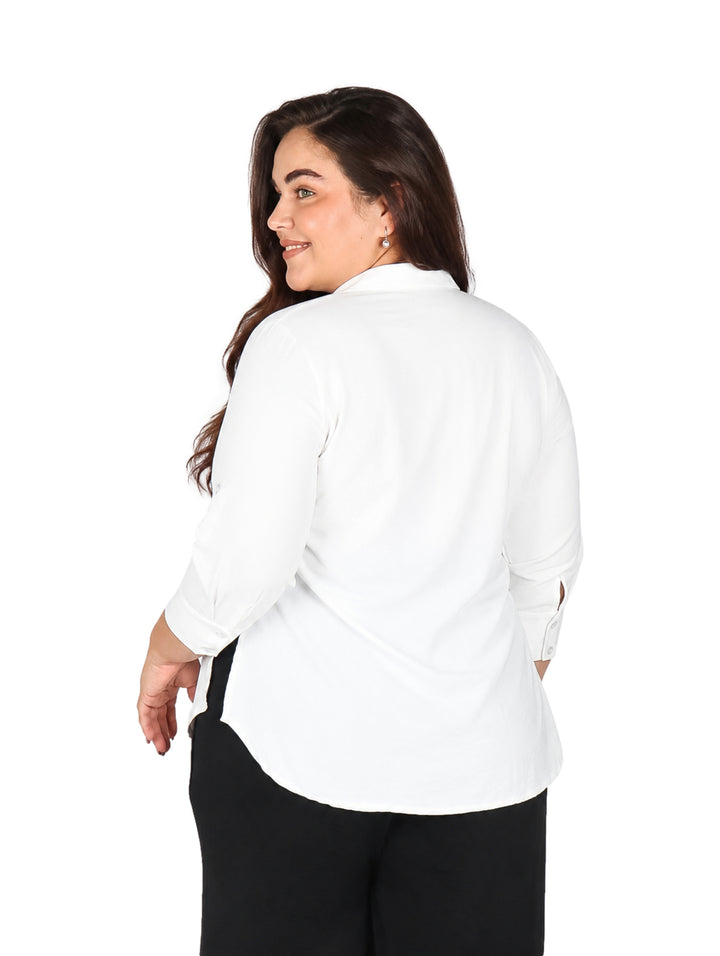 Mujer vistiendo una blusa blanca de manga tres cuartos con cuello y botones.