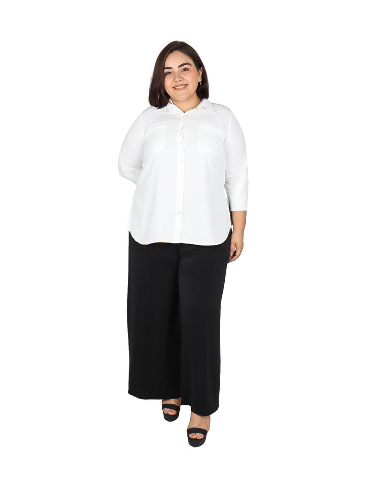 Mujer vistiendo una blusa blanca de manga tres cuartos con cuello y botones.